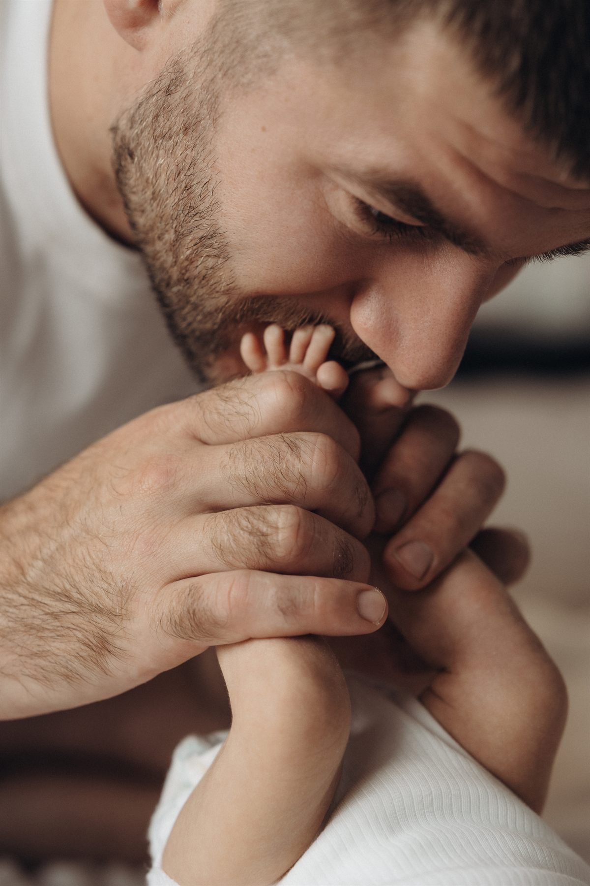 A father kissing his newborn's feet
