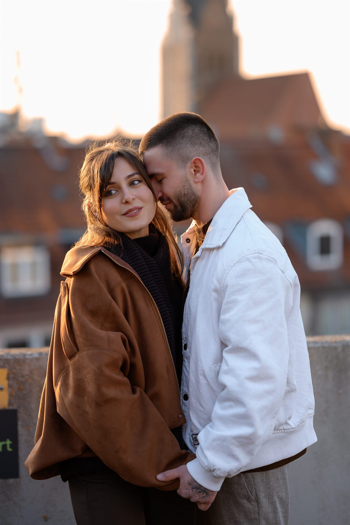 A couple on a rooftop at sunset